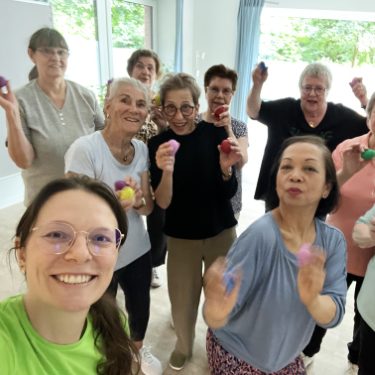 Senioren Gymnastik Angebote Eine Gruppe von Frauen, die zusammen mit bunten Bällen lächeln und posieren.